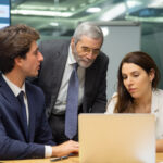 front-view-confident-business-team-looking-laptop