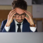 front-view-tired-man-eyeglasses-looking-laptop