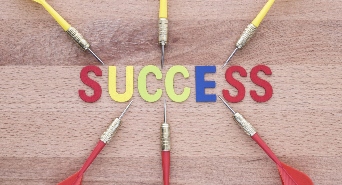 Six dart run in to success target on wooden background. Group of dart (Teamwork) run in to Success target. Abstract success background concept